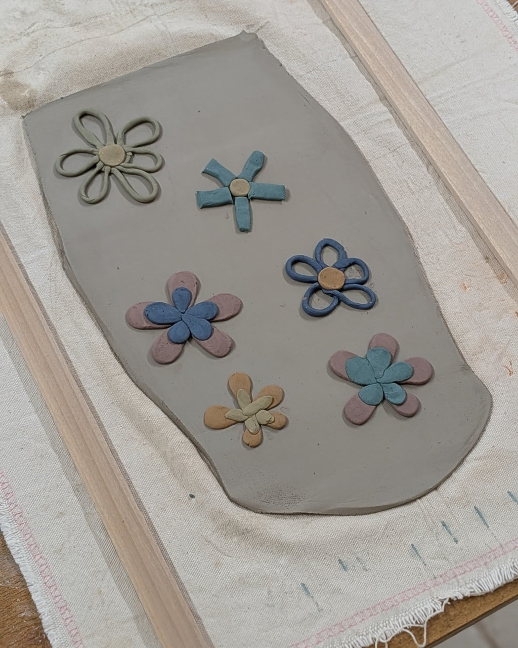 Clay slab with flower-shaped cutouts on a textured surface